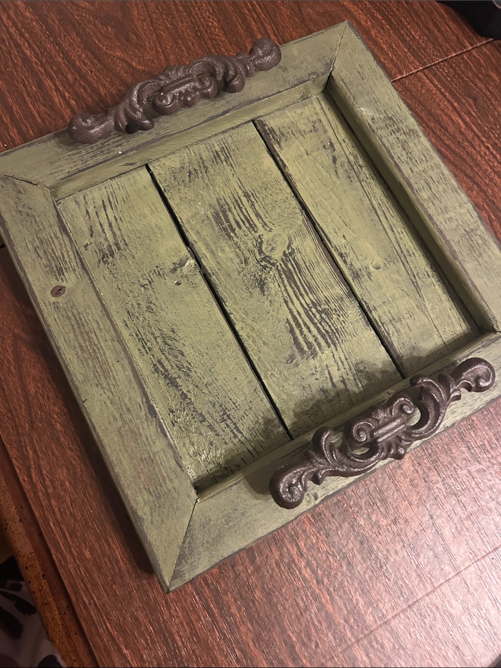 Green tray with heavy iron handles. Looks rustic and beautiful!